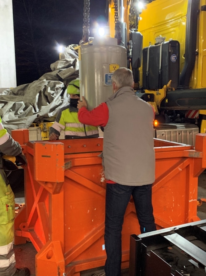 Le conteneur de la source est installé dans la caisse de transport à l’aide d’une grue.