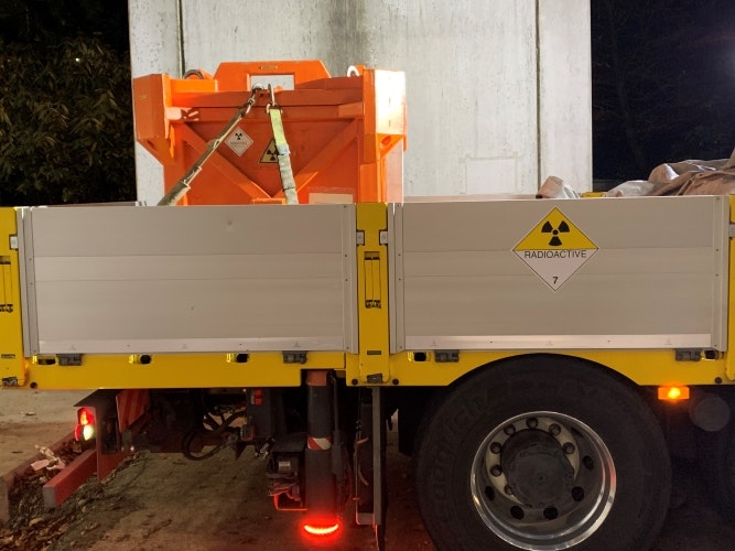 Transporteur de matières dangereuses avec la boîte de transport résistante dans laquelle le conteneur de la source est placé.